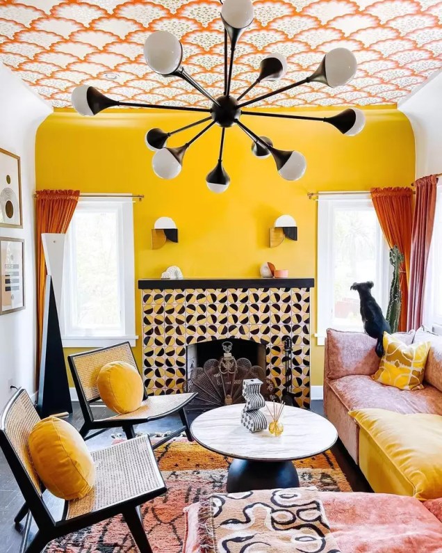 Make it pop! – Se a pop art fosse uma sala de estar, seria algo assim. Um caloroso amarelo canário com tons de laranja dá um impacto sério em uma parede de destaque, enquanto detalhes em preto aterram o resto da sala. Cortinas laranja tornam o espaço aconchegante e convidativo.