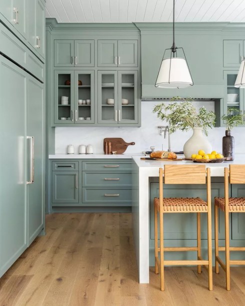 12-38-jeitos-de-incorporar-cor-na-sua-cozinha Muitos projetos de cozinhas optam por pintar os armários superiores ou inferiores. Mas, para realmente injetar um pouco de energia em um espaço, pinte ambos. Mesmo que sereno e tranquilo seja o humor que você deseja, um verde suave como este garantirá que isso aconteça – sem a necessidade do ambiente ficar todo branco ou totalmente neutro.