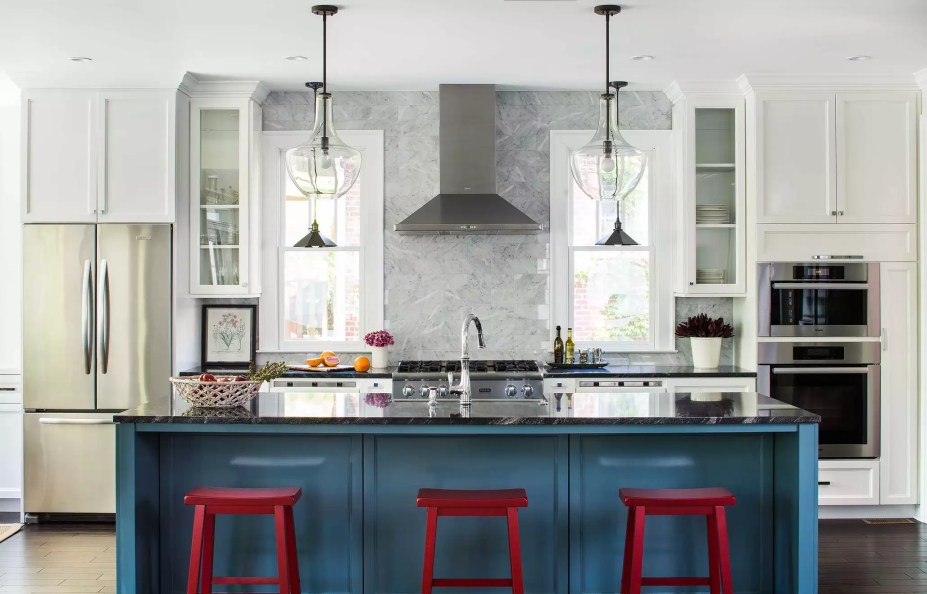 15-38-jeitos-de-incorporar-cor-na-sua-cozinha Aqui, um espaço de cozinha predominantemente branco assinado pela Terracotta Design Build Company prova que as cores primárias são tudo menos juvenis. A ilha de cozinha azul e os bancos vermelhos são peças sofisticadas que se destacam nos armários brancos.