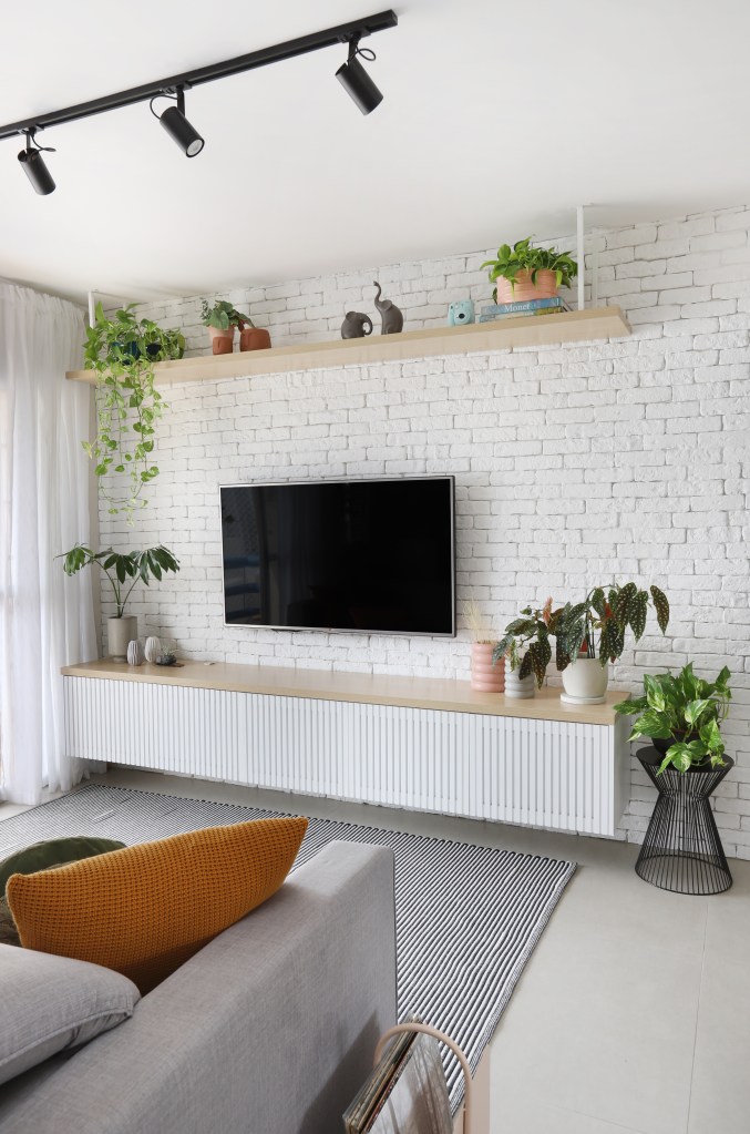 apartamento pequeno; sala de tv; rack branco; parede de tijolinhos; tijolinhos brancos