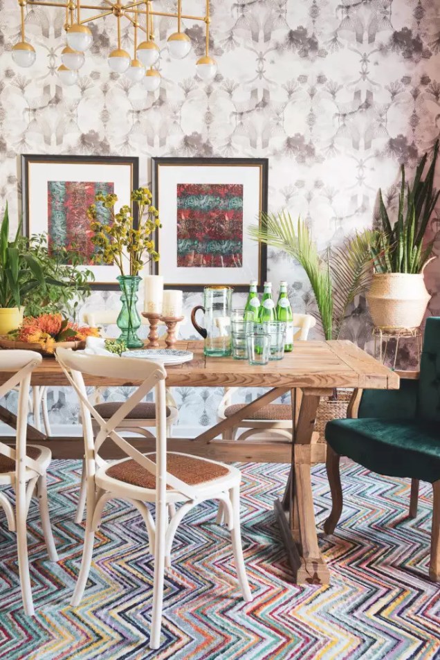 Misture os objetos – para um visual boêmio moderno em sua sala de jantar, insira camadas em estampas contrastantes, cores fortes e muita textura. Uma variedade de opções de assentos realça a aparência intencionalmente eclética, assim como uma abundância de vasos de plantas verdes.