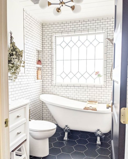 20-ideias-criativas-de-banheiros-com-azulejos-12 <span style="font-weight: 400">Misturar formas é uma das maneiras mais acessíveis para mostrar singularidade e personalidade em um cômodo, não importa a metragem quadrada. Aqui, o revestimento hexagonal imita as formas angulares da janela, enquanto fornece algum contraste com os ladrilhos de metrô nas paredes.</span>