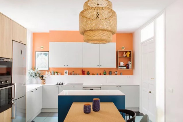 Aqueça os detalhes de cozinha em tons frios com uma cor de parede fresca e quente. Aqui, os designers de interiores da Nimú combinaram um tom alaranjado de salmão com azul marinho.