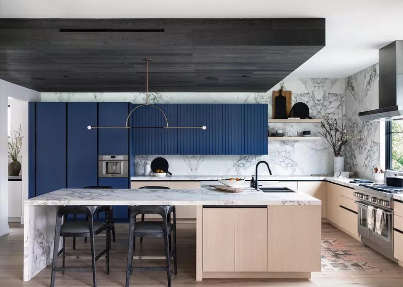 31-38-jeitos-de-incorporar-cor-na-sua-cozinha Você já notou os poderes de design que o marrom e o azul trazem, mas o preto e o azul são outra combinação temperamental que vale a pena ter em mente ao revisar suas opções de cores. Esta cozinha parece um espaço neutro, mas tem um impacto e uma dimensão extra graças aos blocos intencionais de saturação profunda. Para dar um passo adiante, reveja suas opções para blocos de teto e bancadas. Os veios do mármore emitem uma vibração muito diferente do que os grãos da madeira, por exemplo.