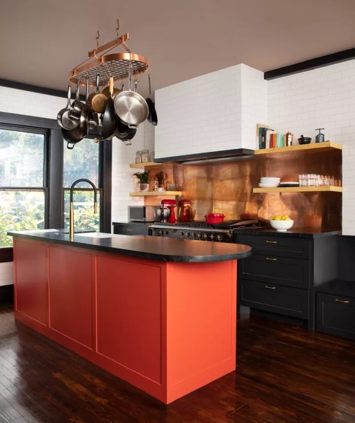 35-38-jeitos-de-incorporar-cor-na-sua-cozinha Laranja lava e preto são duas cores que são inesperadamente perfeitas quando colocadas lado a lado. Têm um ar de rusticismo – especialmente com aquele backsplash de cobre – mas também apontam para os tons de neon que podiam ser encontrados nos anos 80. Essa escolha de cores dá a uma sala originalmente branca algumas vantagens importantes – não se esqueça dos peitoris e enfeites das janelas.