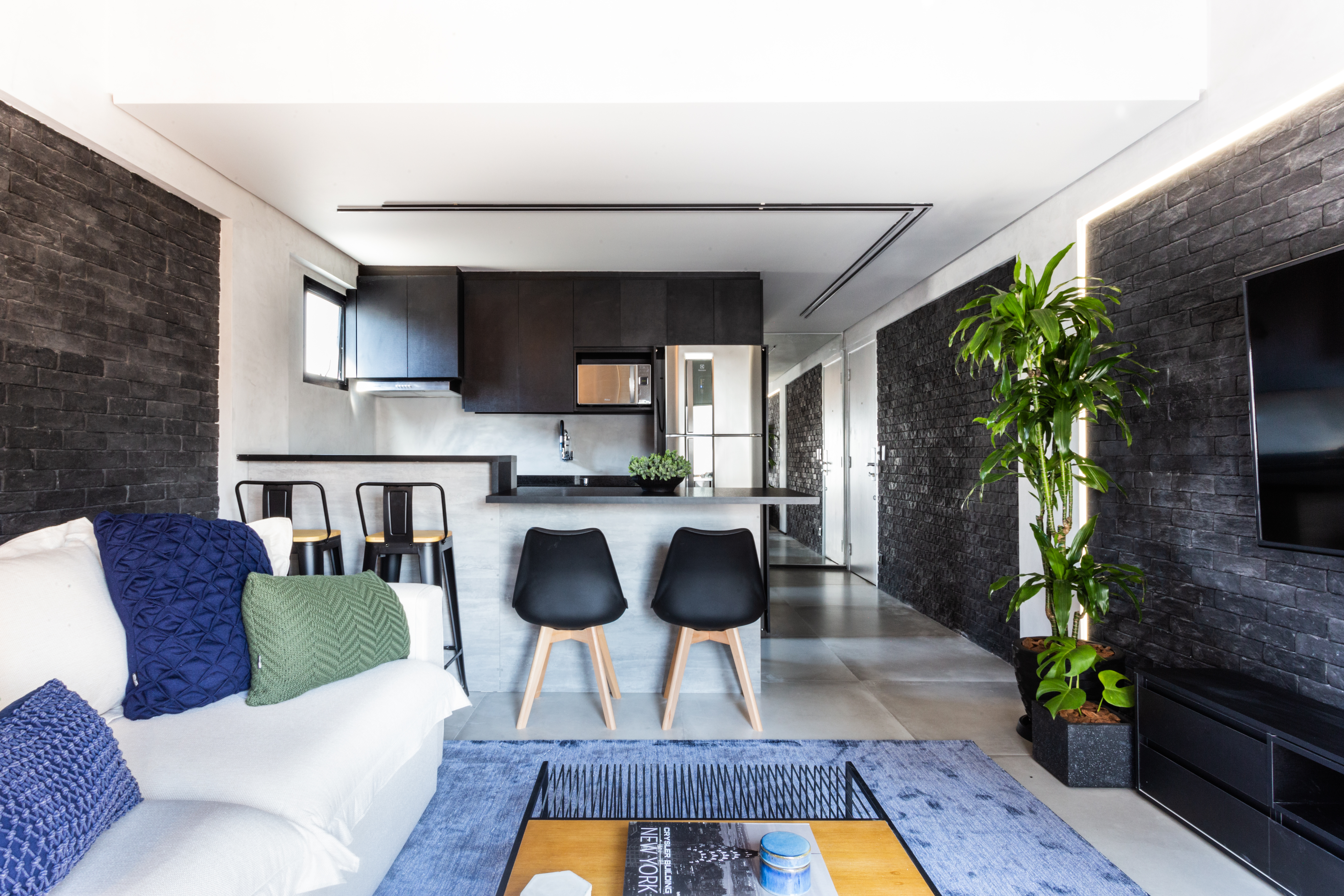 Estilo urban jungle e cores sóbrias transformam este loft de 50 m²