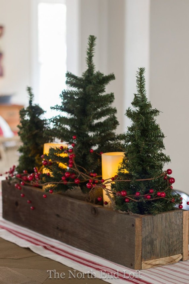 Faça o seu próprio adorno de mesa natalino velas e frutas vermelhas ao redor dele.