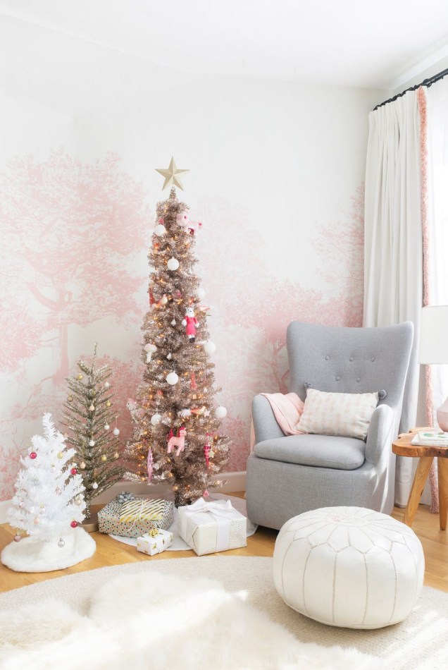 Agrupe algumas árvores de Natal de várias alturas e cores para um esquema de decoração enfeitado. Emily Henderson encontrou o equilíbrio perfeito entre festivo e personalizado neste berçário rosa.