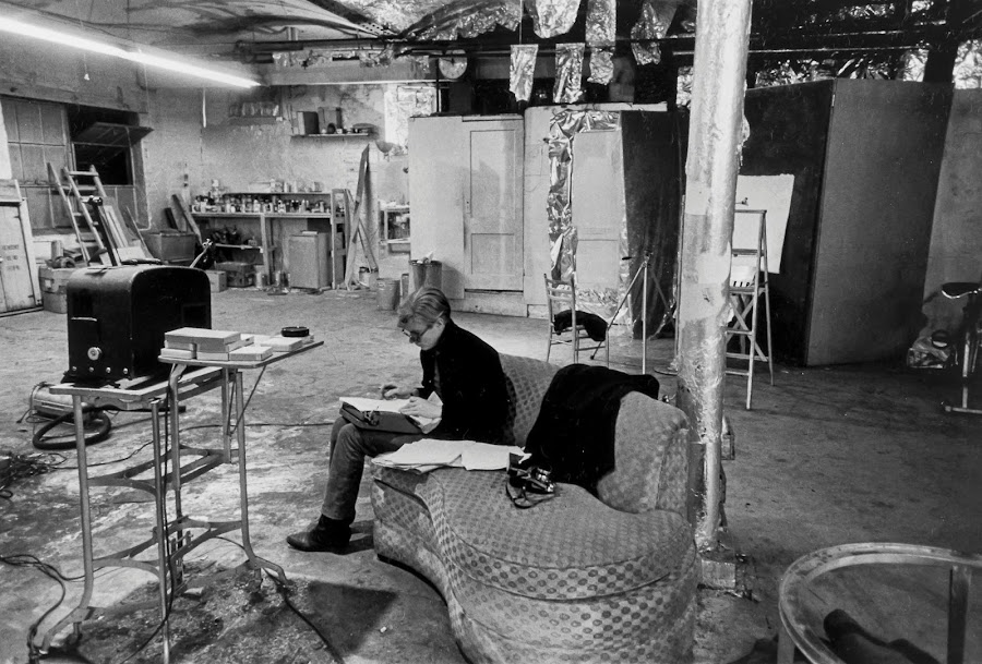 foto preta e branca de Andy Warhol sentado em sofá em seu flat