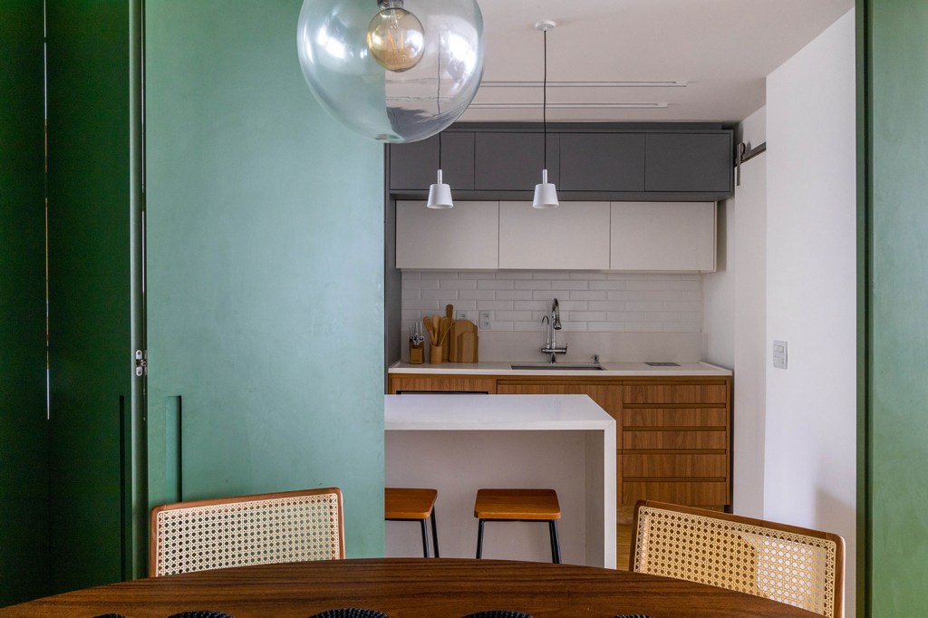 Visão parcial da cozinha com bancada, com móveis nas cores branca e cinza