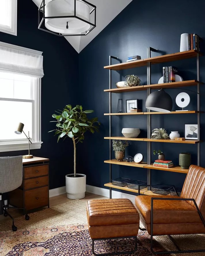 Home office com paredes em azul escuro