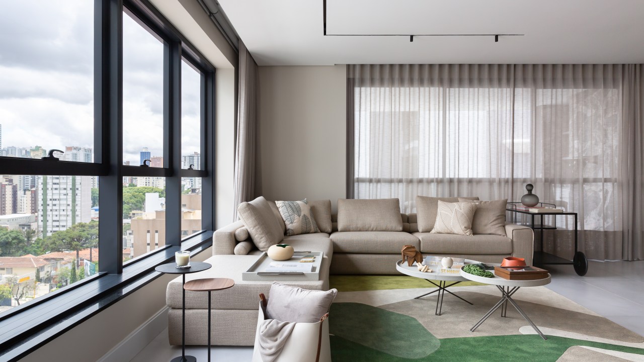 Sala de estar com sofá neutro e tapete verde