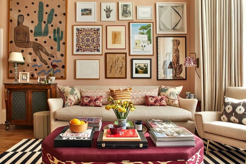 Sala de estar com gallery wall, muita arte, sofá branco, mesa de centro vinho e decoração eclética