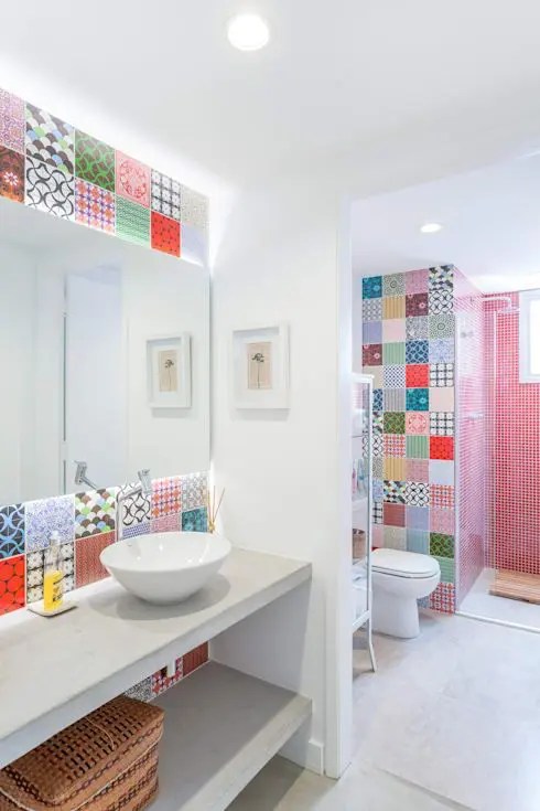 Um banheiro contemporâneo com azulejos vermelhos no espaço do chuveiro e azulejos impressos super ousados ​​no resto do ambiente