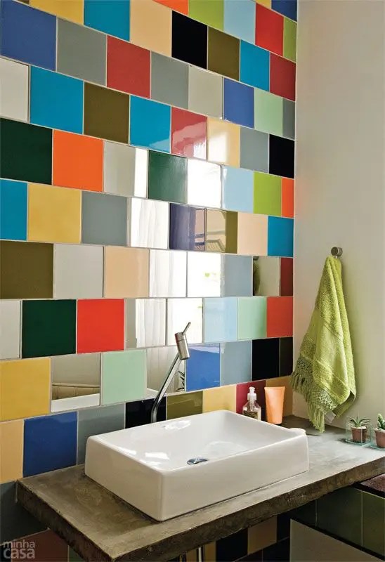 Banheiro moderno revestido por peças coloridas sobre a pia é uma solução brilhante e inesperada que impressiona