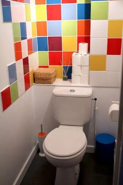 Este toalete pequeno foi renovado com azulejos multicoloridos brilhantes