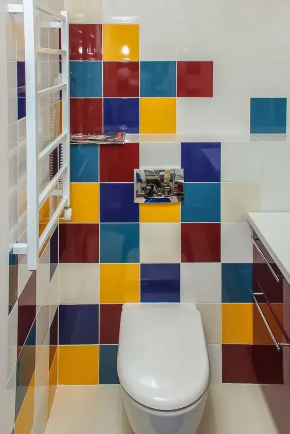 Um pequeno lavabo com azulejos multicoloridos e uma pia bordô super estilosa