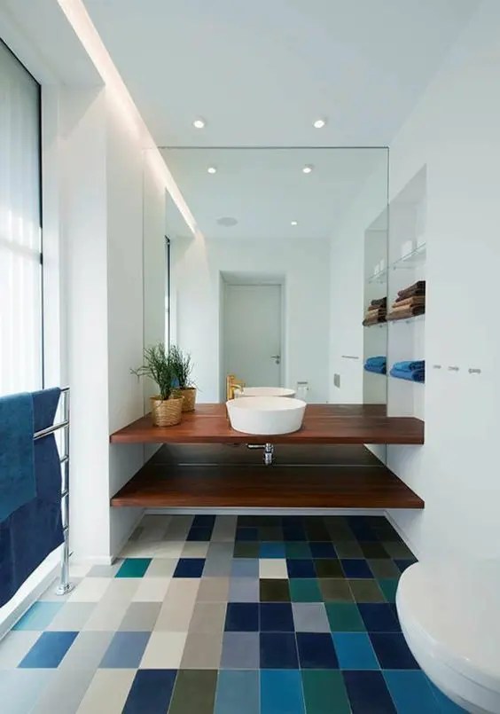 Um banheiro moderno e elegante branco, mas com um piso de ladrilho colorido