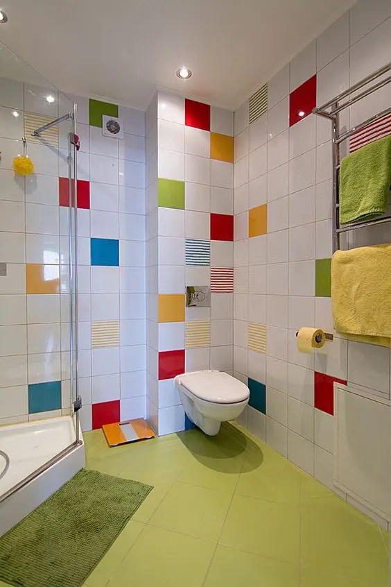 Banheiro branco com piso verde neon e azulejos brilhantes acentuando as paredes