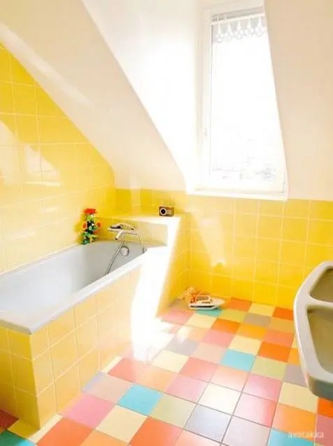 Banheiro amarelo e branco com piso de ladrilho colorido é uma ideia divertida para levantar o ânimo