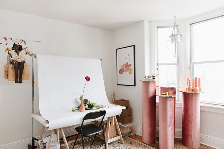 Mito-ou-verdade-Decoração-de-espaços-pequenos-estudio Estudio com mesa para fotos e quatro mesinhas altas, de tamanhos diferentes, e rosas