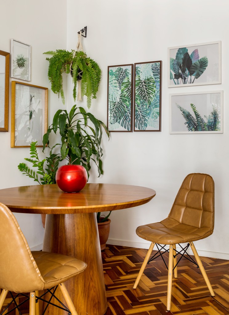 Mesa de jantar de madeira com quadros na parede