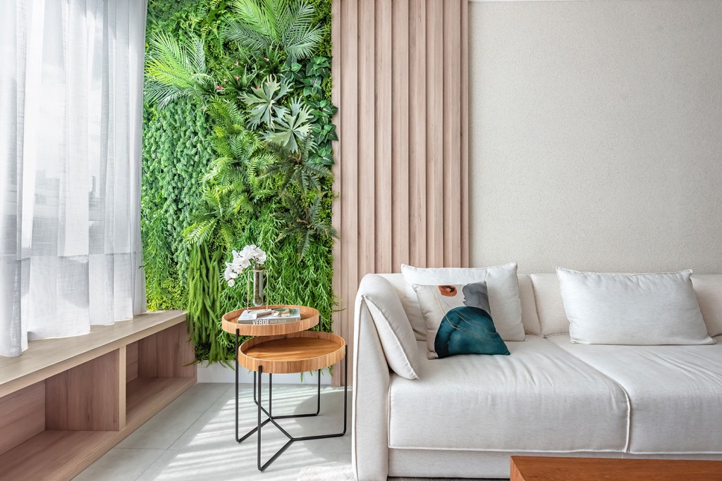 ape-de-140-m²-recebe-reforma-que-mescla-estilo-provencal-com-boho-chic-carol-zamboni-arquitetos-giovanna-goncalves-18 Detalhe da sala de estar com sofá branco e parede vida e mesa lateral com duas peças de tampo redondo
