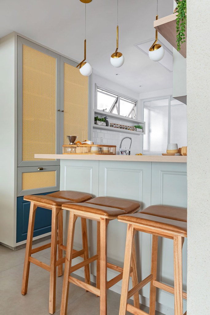 ape-de-140-m²-recebe-reforma-que-mescla-estilo-provencal-com-boho-chic-carol-zamboni-arquitetos-giovanna-goncalves-19 Bancada da cozinha, com bancos e armário de palha