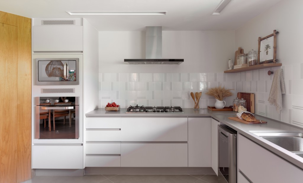 Cozinha ampla e branca em casa de praia