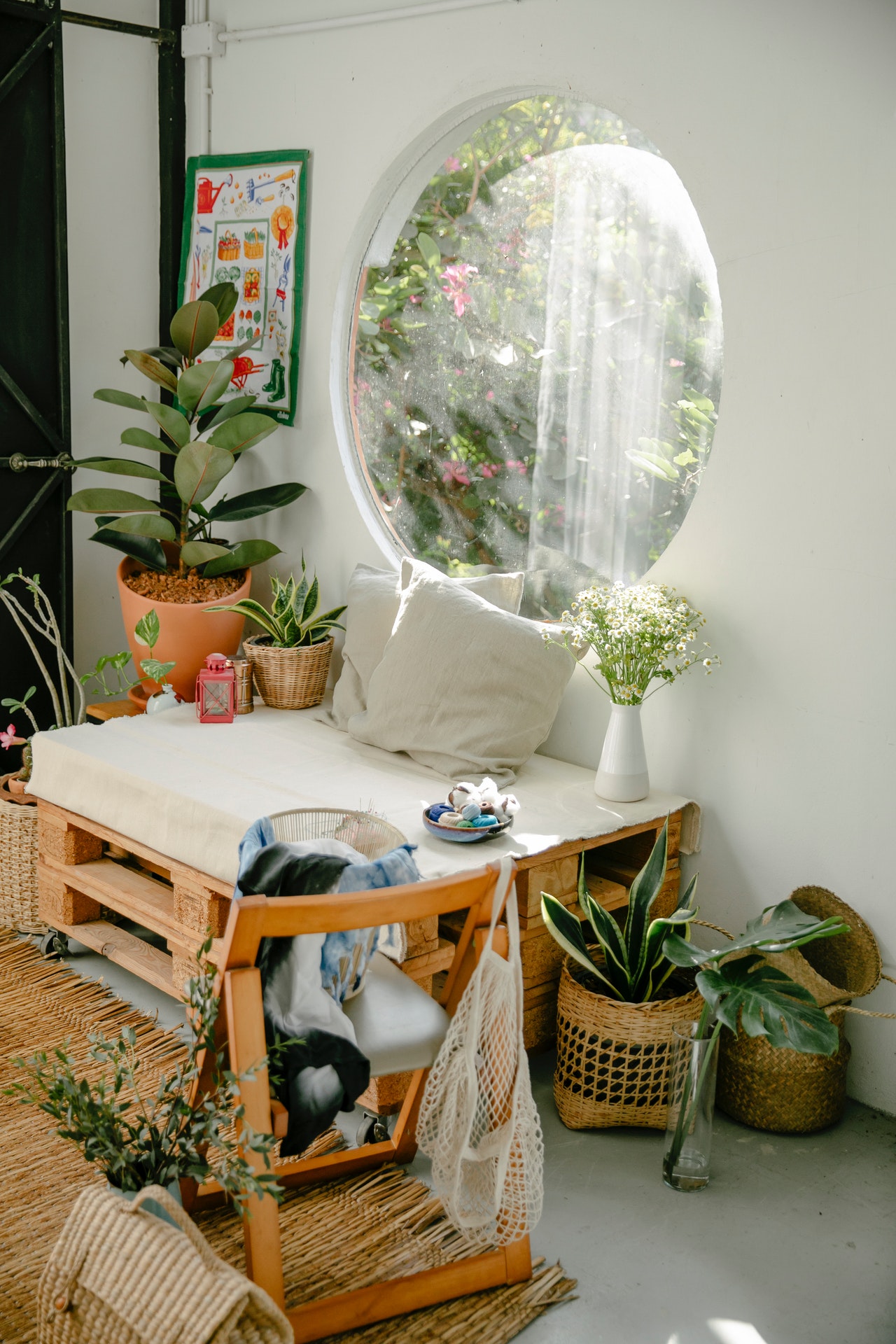 plantas-vaso-terracota Canto com sofá de pallets cercado de vasos, janela circular ao lado