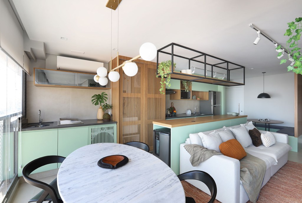 Sala de estar integrada com varan e cozinha, com móveis em tons de madeira e verde claro