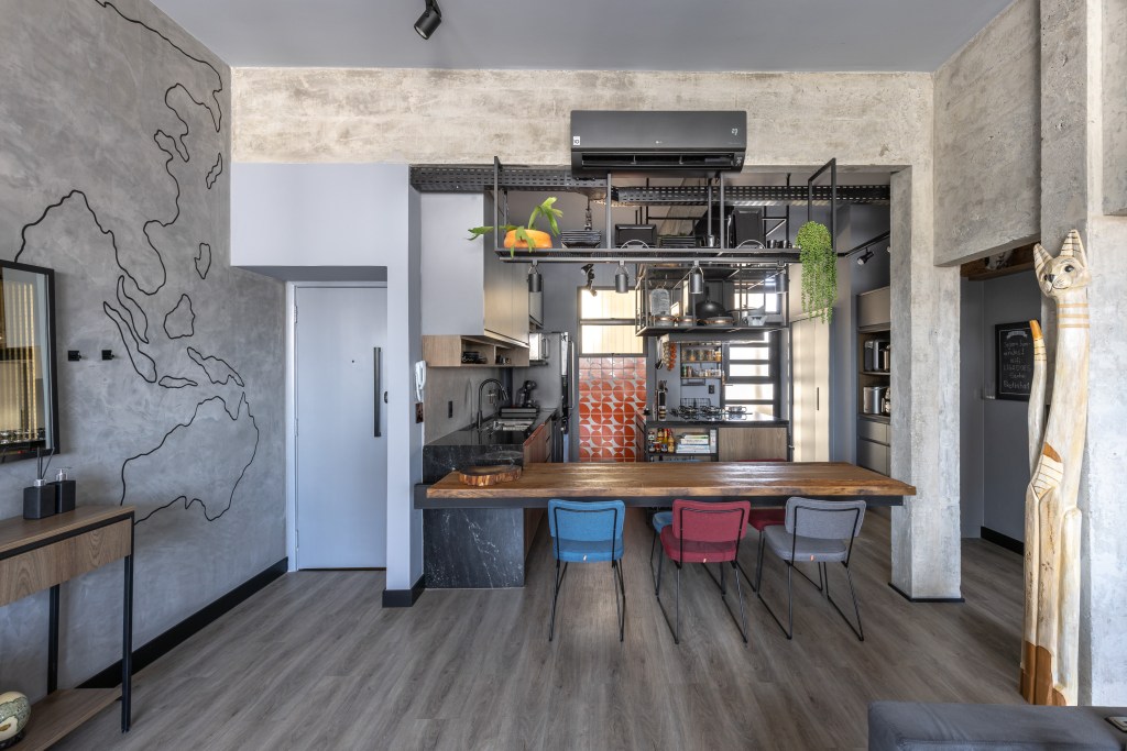 Cozinha integrada à sala de estilo industrial, parede de cimento queimado