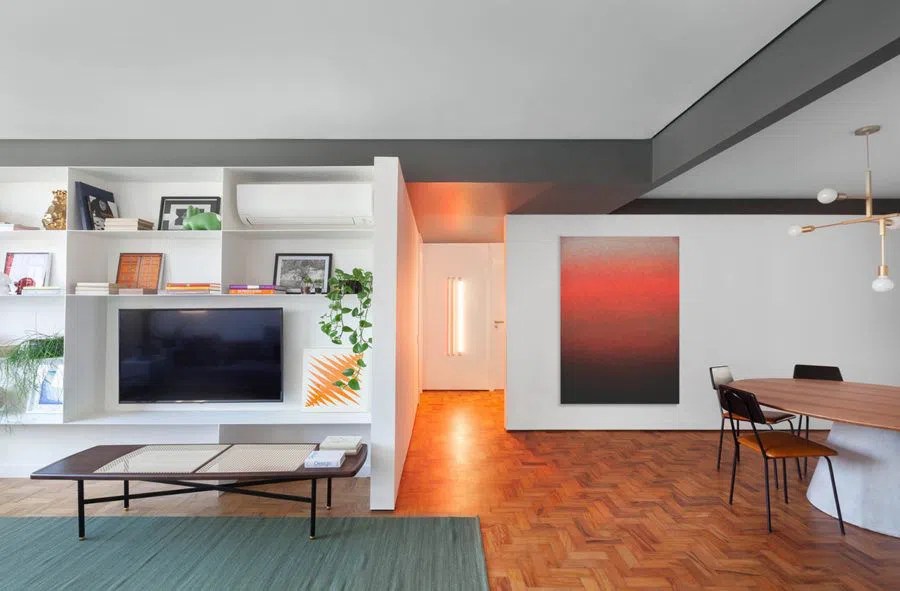 Salas integradas com mesmo piso, quadro colorido e tapete azul
