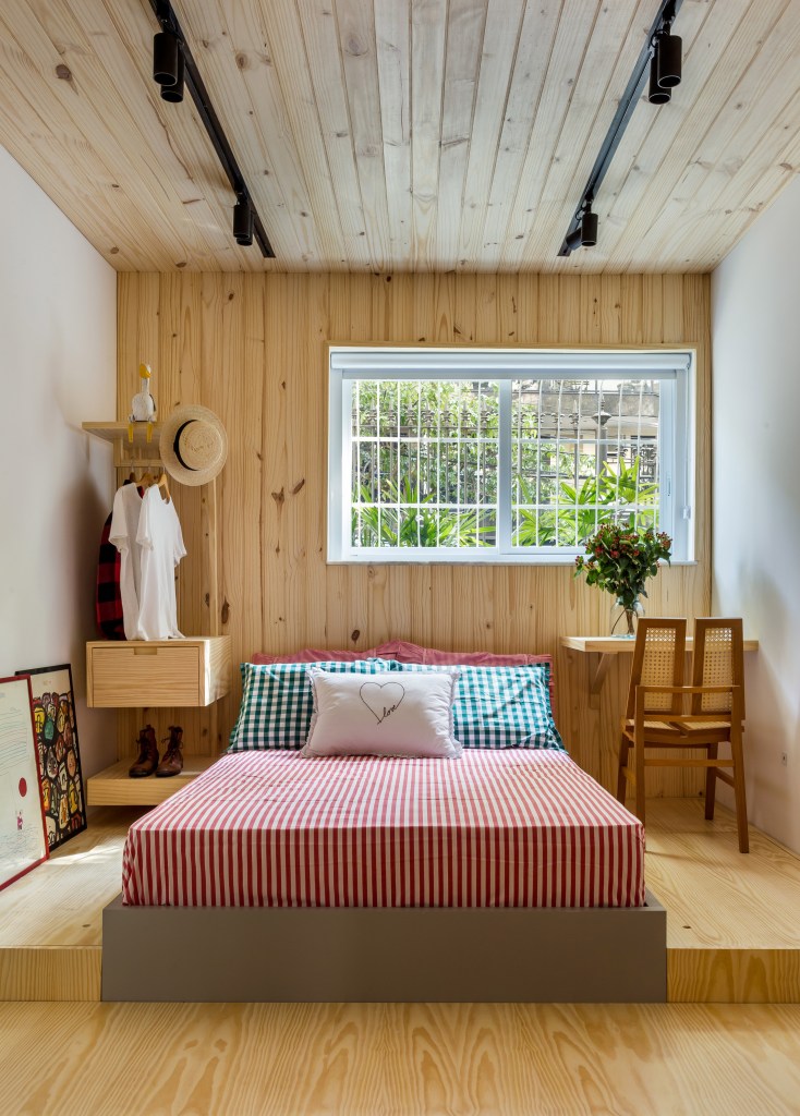Quarto de apartamento pequeno com painel de madeira