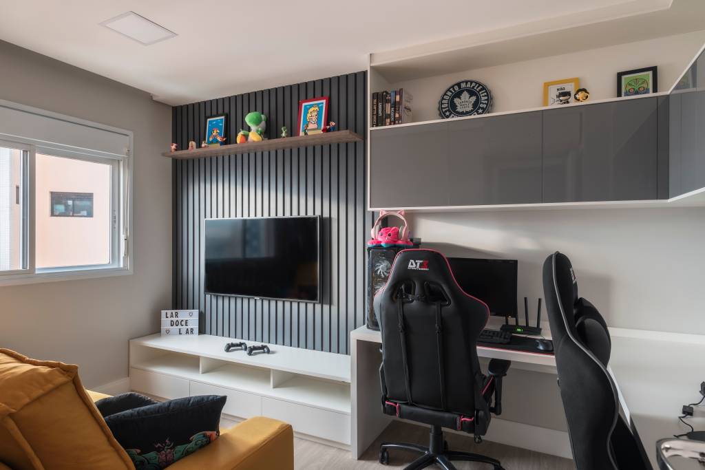 23-integração-varanda-gourmet-e-quarto-gamer-confira-o-projeto-deste-apê Quarto gamer com cadeira gamer, TV e sofá