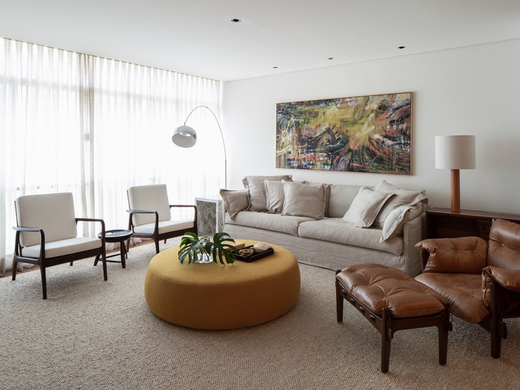 Sala de estar com móveis assinados, decoração neutra e base minimalista