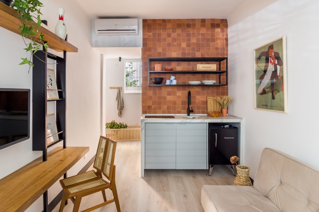 Mini loft com parede de azulejos e cozinha pequena