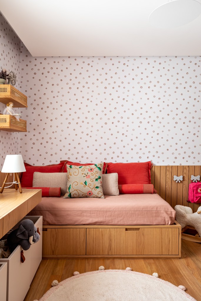 Quarto de menina com cama de madeira e papel de parede rosa
