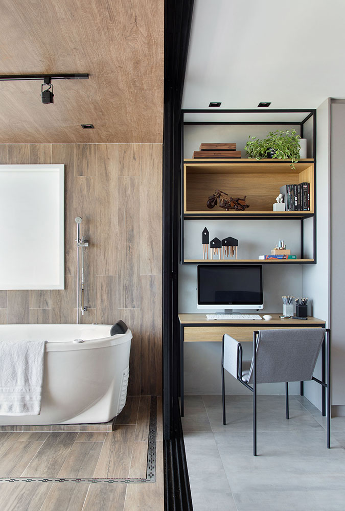 Apartamento tipo loft com 45m2 assinado pela J1 ARQUITETURA E ENGENHARIA _ foto 9-banheiro-integrado Banheira de imersão solta. Home office visível ao lado