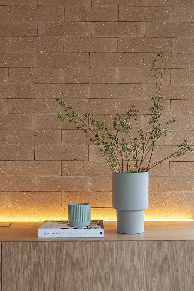 Vaso de cerâmica; parede de tijolinhos ao fundo