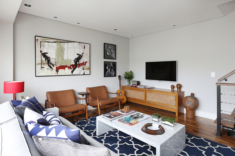 Living com sofá, poltrona, rack e tapete azul