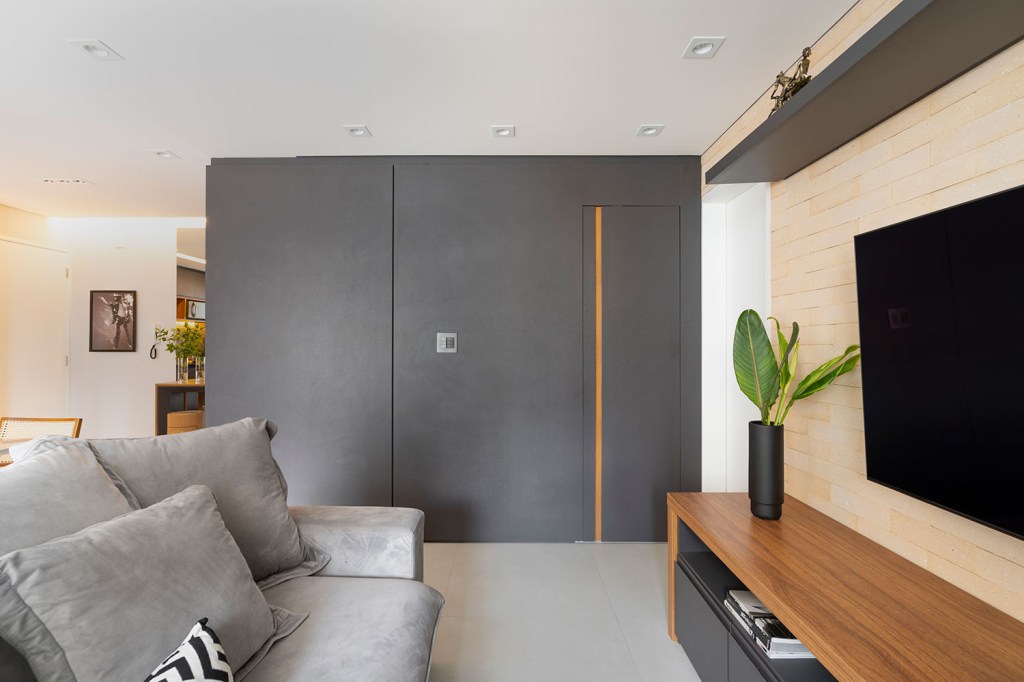 Apartamento com sala integrada ampla mobiliário em preto, madeira e branco