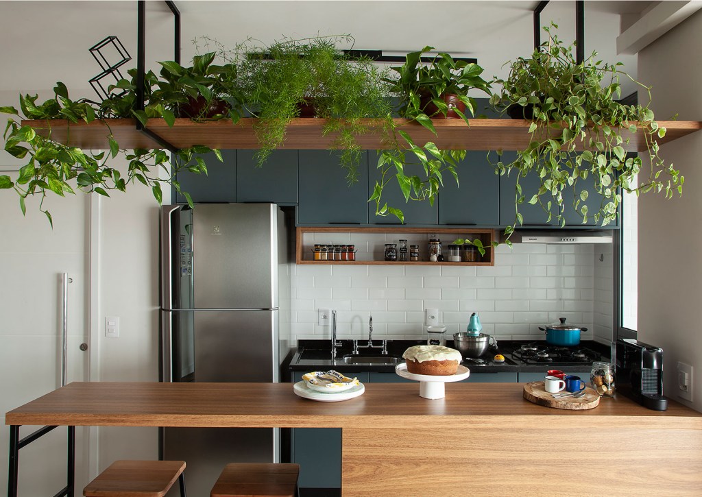 Nessa cozinha integrada ao estar projetada pela Tesak Arquitetura, foi a bancada com espaço para banquetas que serviu como setorizador de ambientes