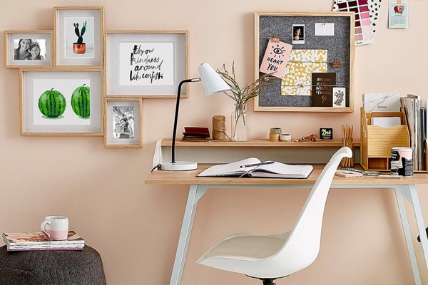 Cantinho de estudos; home office; cadeira eams branca com mesa pequena; quadros na parede; luminária