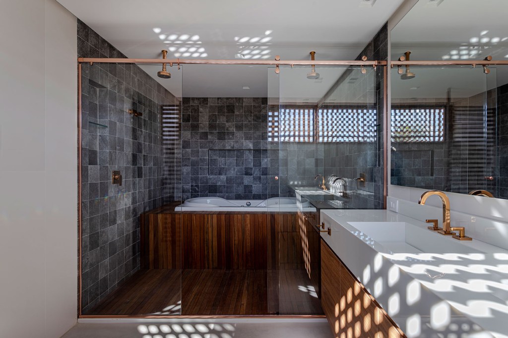 estilo-contemporaneo-guia-construcao-da-casa-muxarabi-na-bahia-casa.com-sidney-quintela-gabriela-daltro-38 Banhiro do casal, com revestimento de tijolinho em tons de cinza e madeira, com pia em pedra branca e banheira