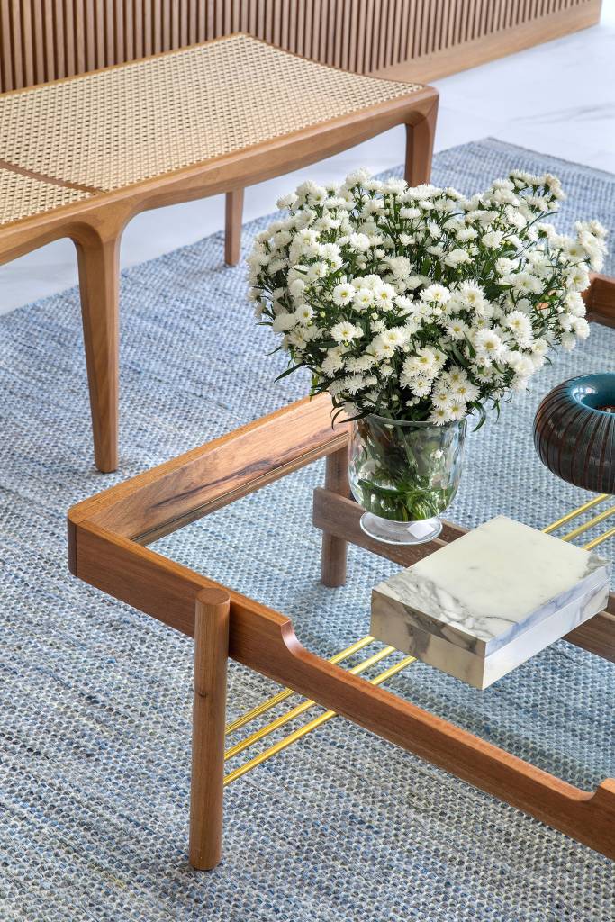 Detalhe da sala de estar: mesa de centro com vaso de vidro e floeres brancas