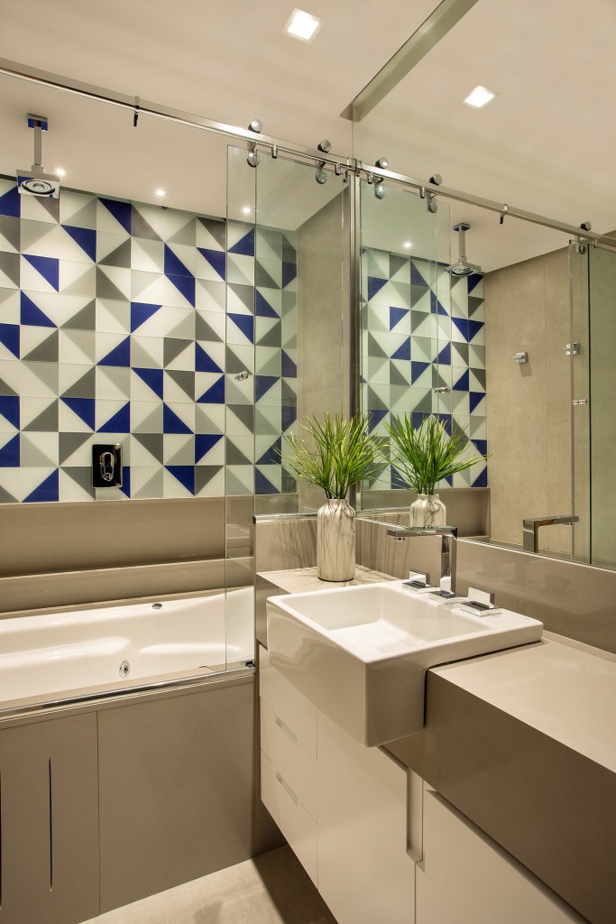 Banheiro em tons de cinza, com azuleijos geométricos e banheira de hidromassagem