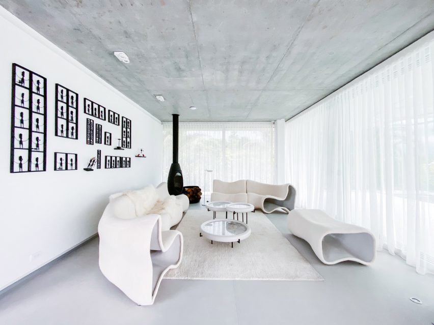 Sala de estara minimalista com mobiliário branco, com formas orgânicas