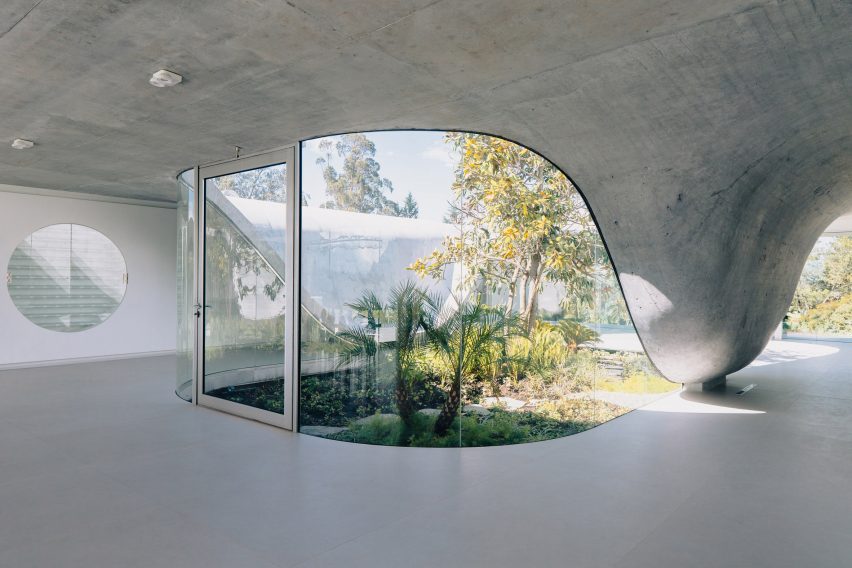 Área entral da casa, onde a Magnólia está situada envolta por uma estrutura de vidro e concreto.