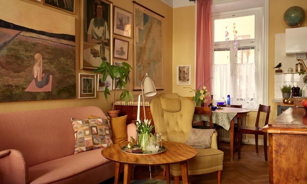 Sala de estar vintage com décor amarelo e sofá rosa
